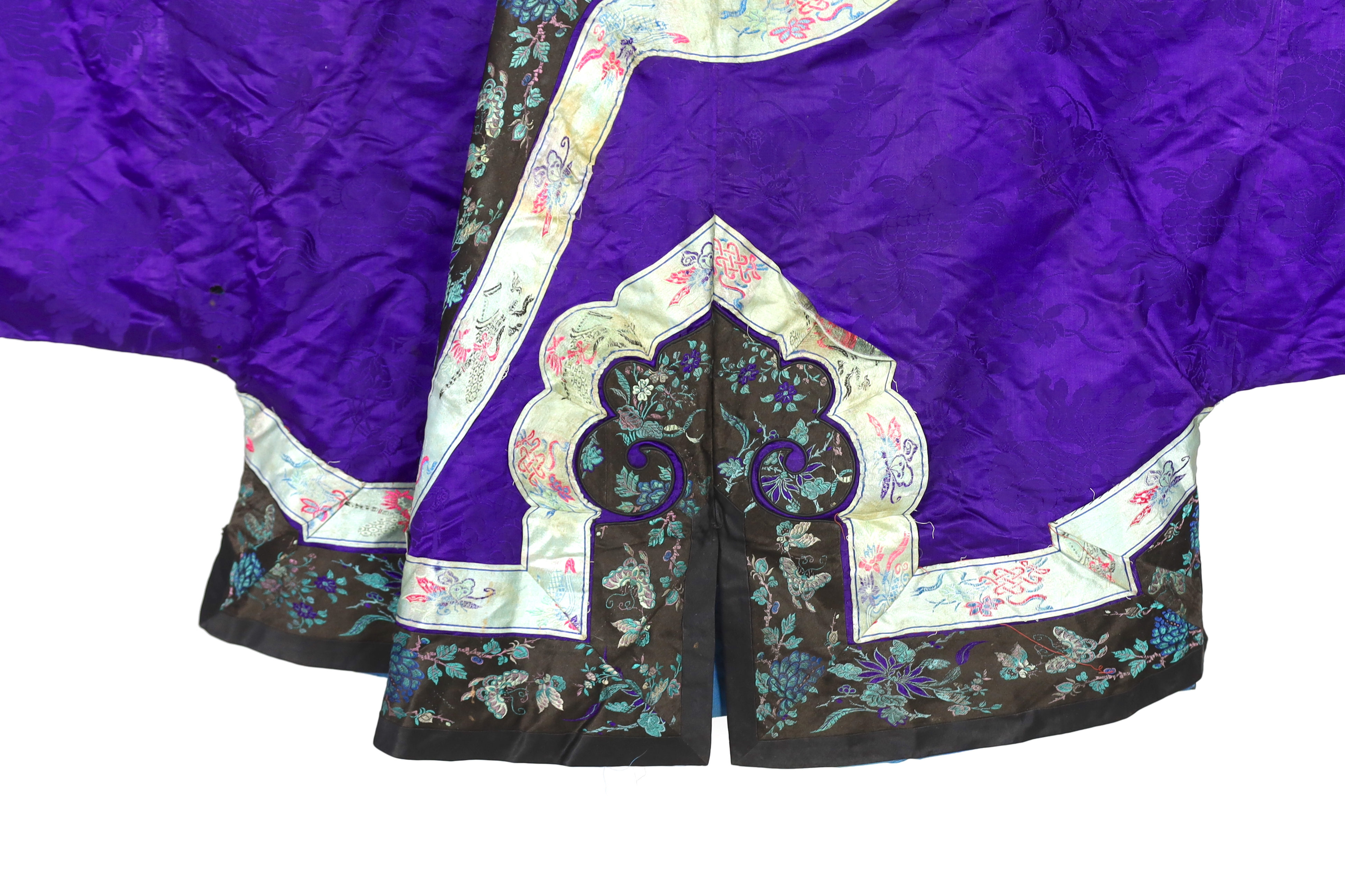 A Chinese purple damask jacket, circa late 19th / early 20th century, decorated with black and turquoise embroidered braiding with auspicious symbols, butterflies and flowers embroidery, 63cm long